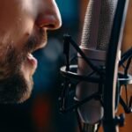 A close up of a man talking into a microphone as he records an advertisement